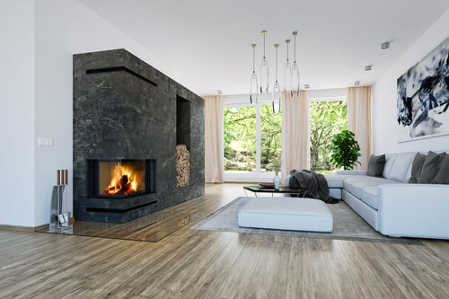 living modern cu semineu pe lemne romotop, colt stanga, integrat intr-un perete elegant finisat cu piatra neagra. flacarile sunt vizibile prin sticla panoramica, oferind un efect spectaculos. zona de relaxare include o canapea alba spatioasa, o masuta minimalista si un perete vitrat cu vedere catre gradina. depozit pentru lemne integrat lateral, completand designul sofisticat al incaperii.modern